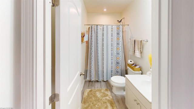 bathroom with vanity, wood-type flooring, a shower with shower curtain, and toilet