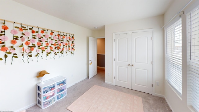 unfurnished bedroom featuring light carpet and a closet