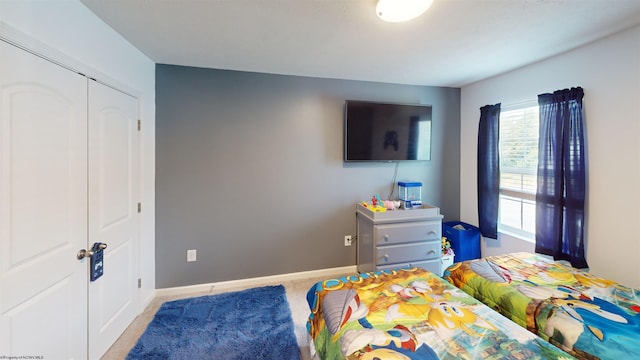 bedroom with a closet and light carpet