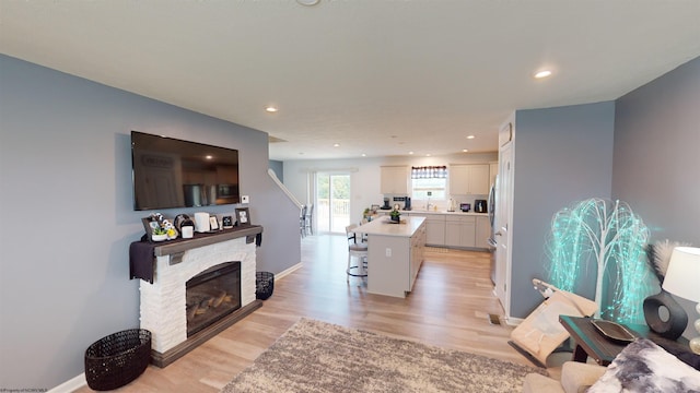 living room with a fireplace and light wood-type flooring