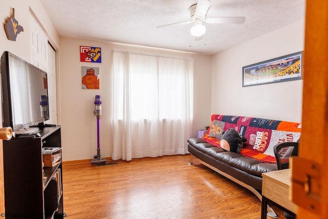 living room with ceiling fan and light wood-type flooring