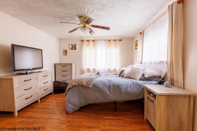 bedroom featuring a textured ceiling, ceiling fan, and hardwood / wood-style floors