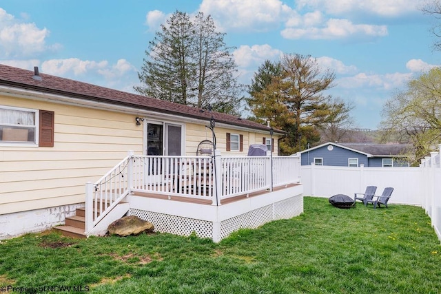 rear view of house with a deck and a yard