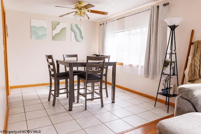 dining room featuring a textured ceiling, ceiling fan, and light tile patterned floors