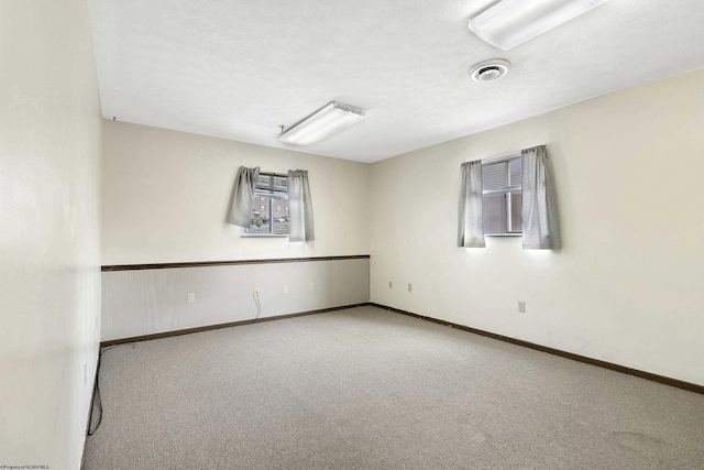 unfurnished room with light carpet and a textured ceiling