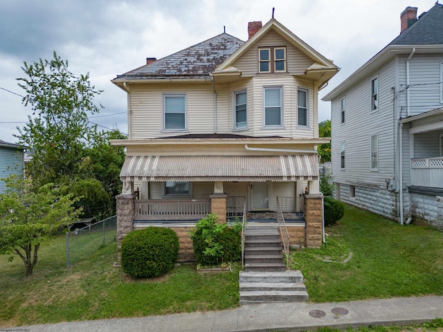 victorian-style house with a porch and a front lawn