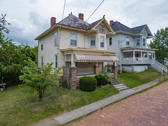 victorian house with a porch and a front lawn