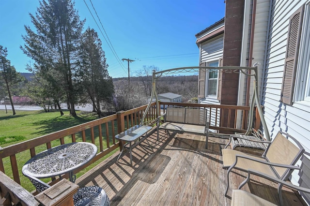 wooden terrace featuring a yard