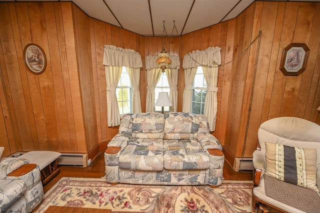 living room with hardwood / wood-style floors, wooden walls, and a baseboard radiator