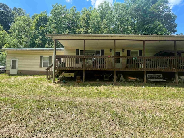 rear view of house featuring a deck and a yard