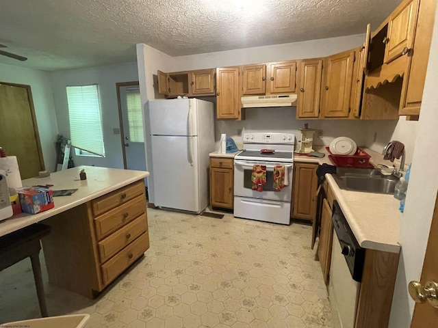 kitchen with light floors, light countertops, a textured ceiling, white appliances, and under cabinet range hood