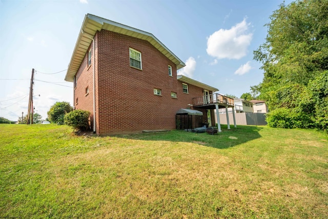 back of house featuring a wooden deck and a lawn