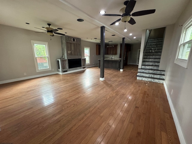 unfurnished living room featuring hardwood / wood-style flooring and ceiling fan