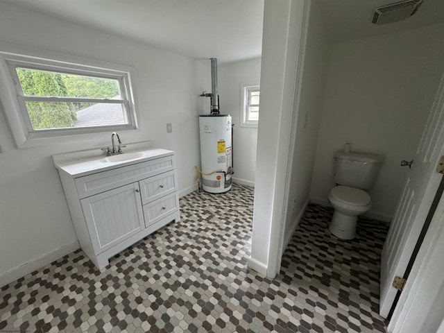 bathroom featuring gas water heater, vanity, and toilet