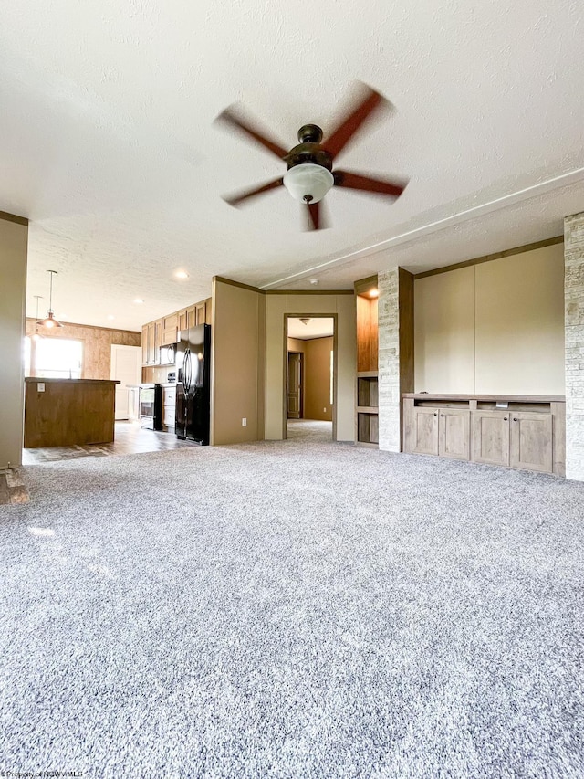 unfurnished living room featuring a textured ceiling, carpet, and ceiling fan