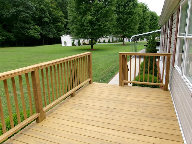 wooden terrace with a storage shed and a yard