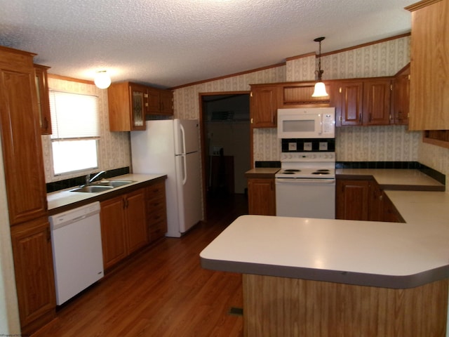 kitchen with sink, decorative light fixtures, a textured ceiling, white appliances, and hardwood / wood-style floors