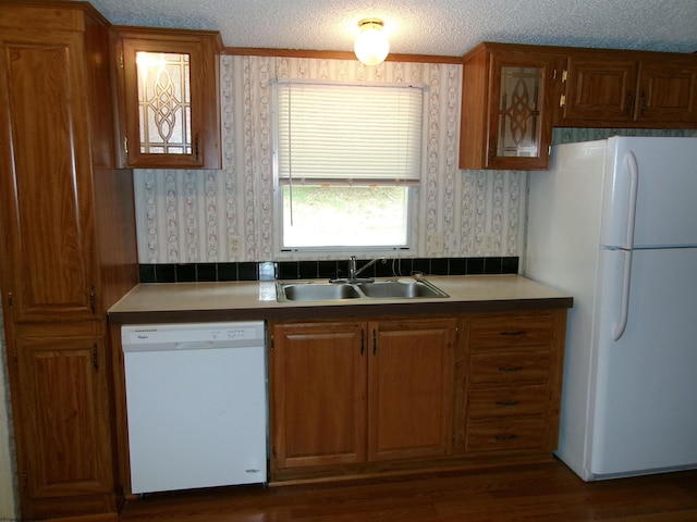 kitchen with white appliances, dark hardwood / wood-style floors, sink, and a textured ceiling