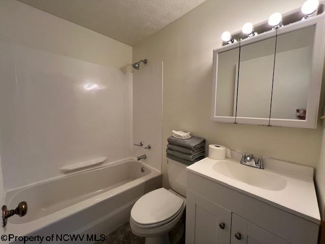 bathroom with shower / washtub combination, a textured ceiling, toilet, and vanity