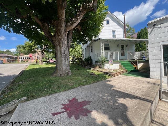 country-style home featuring covered porch and a front lawn