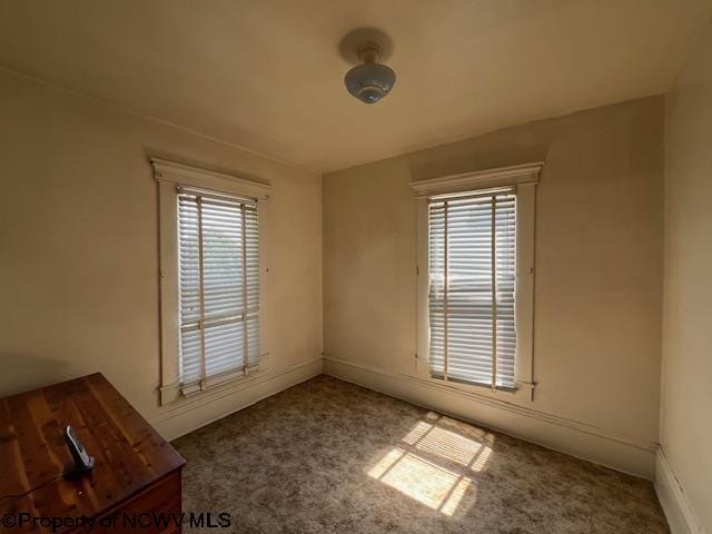 carpeted empty room featuring baseboards