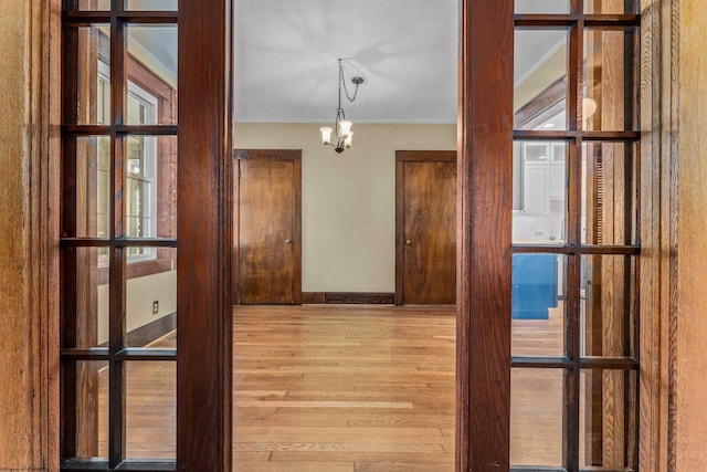 hall featuring light hardwood / wood-style floors and a notable chandelier