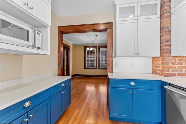 kitchen featuring white cabinetry, light hardwood / wood-style flooring, dishwasher, and pendant lighting