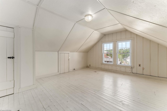 bonus room featuring vaulted ceiling and light hardwood / wood-style floors