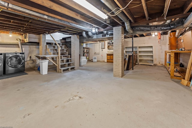 basement with brick wall and washer and dryer