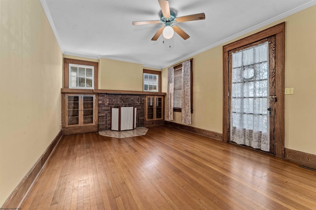 unfurnished living room featuring ceiling fan, crown molding, hardwood / wood-style flooring, and a healthy amount of sunlight