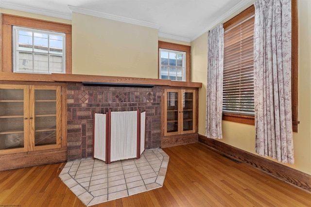 unfurnished living room with ornamental molding and wood-type flooring