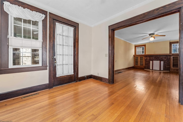 entryway with radiator, ornamental molding, ceiling fan, and hardwood / wood-style floors