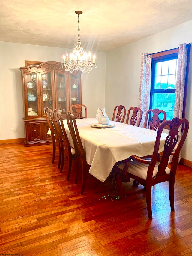 dining area featuring hardwood / wood-style floors and a chandelier