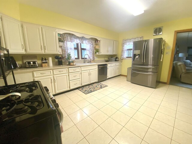 kitchen with black dishwasher, range with gas stovetop, white cabinets, sink, and stainless steel fridge with ice dispenser