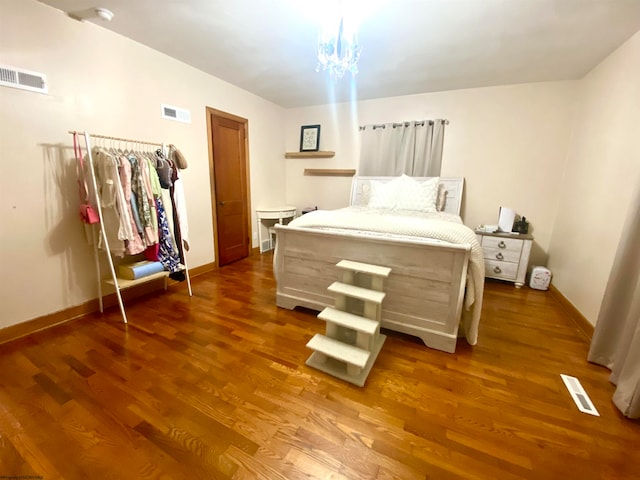 bedroom with a chandelier and wood-type flooring