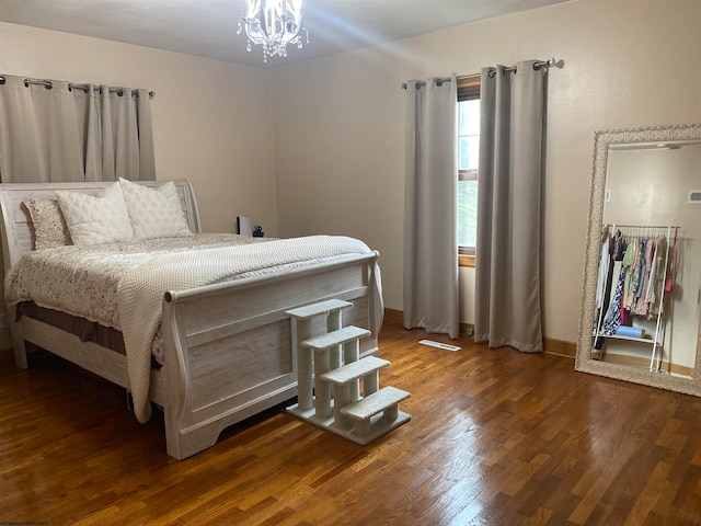 bedroom with hardwood / wood-style flooring and a notable chandelier