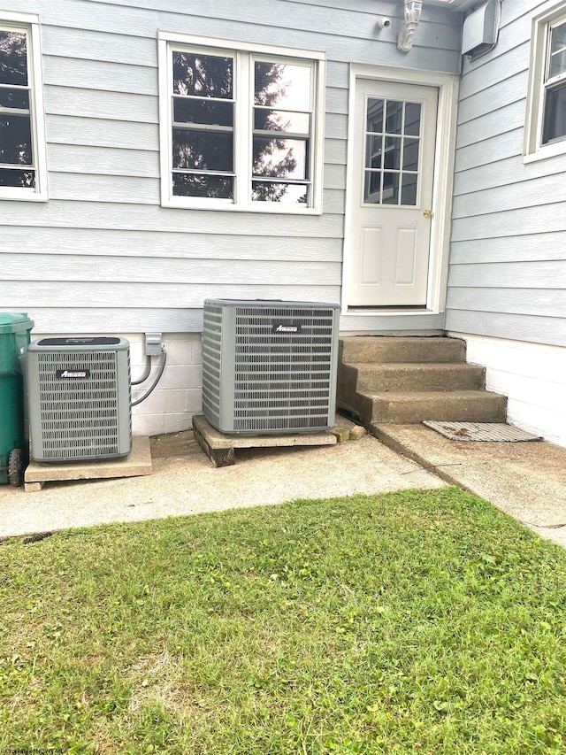 property entrance featuring a yard and cooling unit