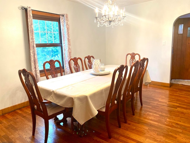 dining space with hardwood / wood-style flooring and an inviting chandelier