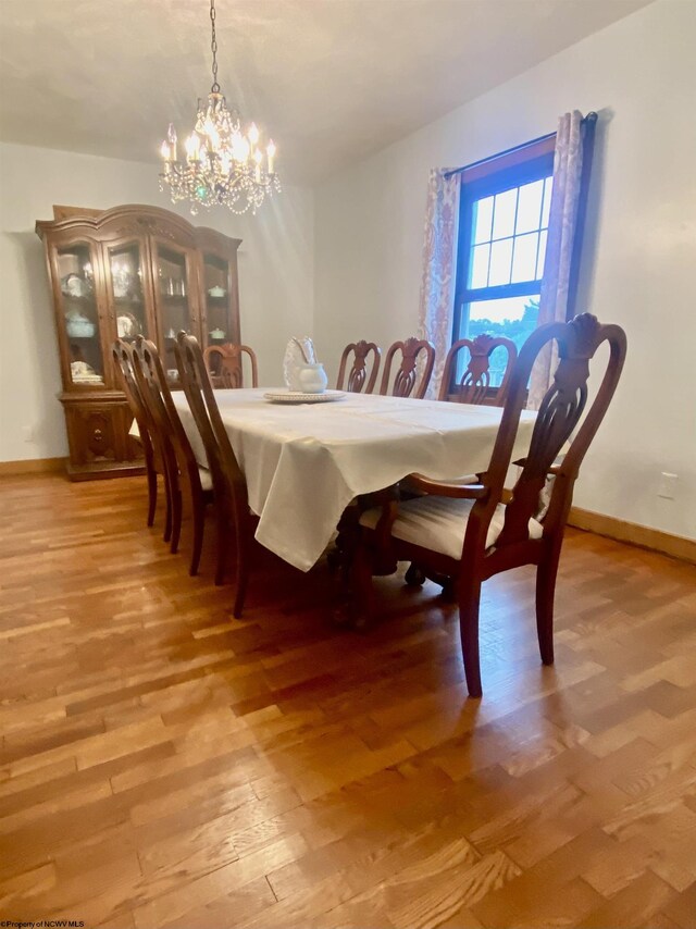 dining area featuring light hardwood / wood-style floors and an inviting chandelier