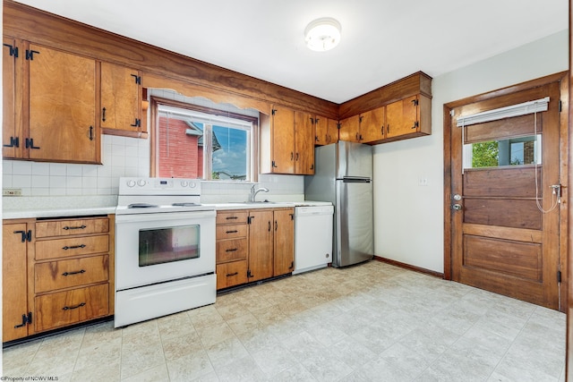 kitchen with sink, tasteful backsplash, white appliances, and light tile patterned floors