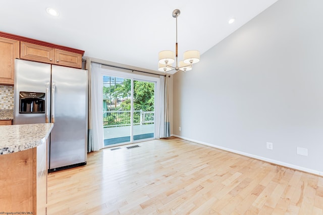 kitchen with lofted ceiling, light hardwood / wood-style flooring, tasteful backsplash, decorative light fixtures, and stainless steel refrigerator with ice dispenser