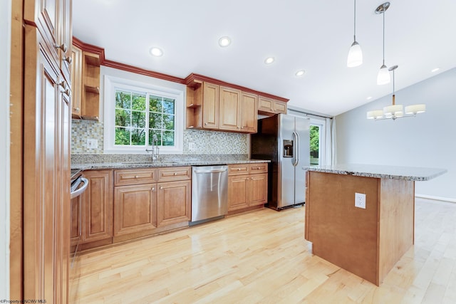 kitchen with light hardwood / wood-style flooring, pendant lighting, tasteful backsplash, and stainless steel appliances