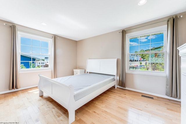 bedroom featuring light hardwood / wood-style floors and multiple windows