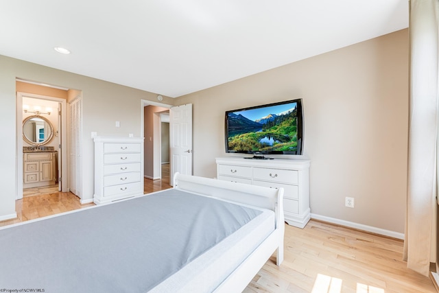 bedroom with light hardwood / wood-style flooring and connected bathroom