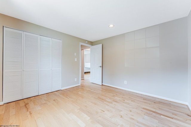 unfurnished bedroom featuring light hardwood / wood-style floors and a closet