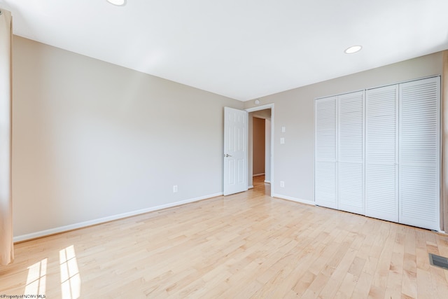 unfurnished bedroom featuring light hardwood / wood-style flooring and a closet