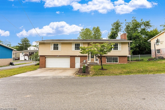 split foyer home featuring a garage and a front lawn