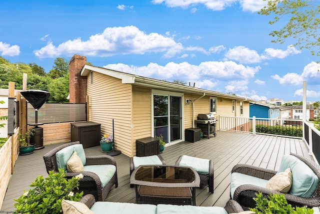 wooden deck with area for grilling and an outdoor hangout area