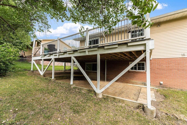 back of property featuring a lawn and a wooden deck