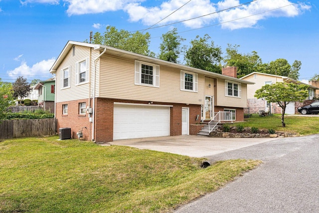 split foyer home with cooling unit, a garage, and a front lawn